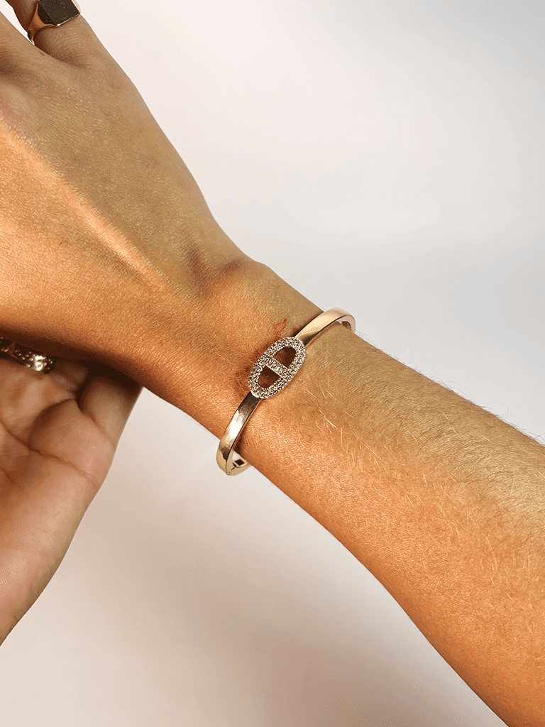 Pulseira Dourada Aberta com Detalhe Oval Cravejado